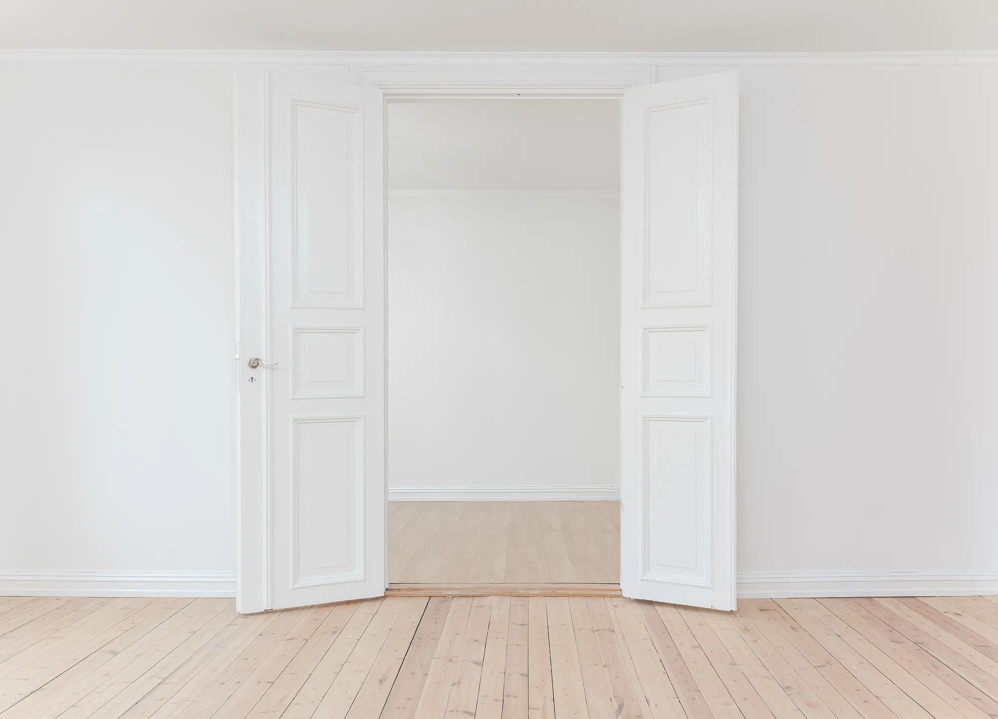 Corner of a room with a wide window wall and a nearby door